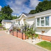 A long driveway leading to two residential park homes and a garage